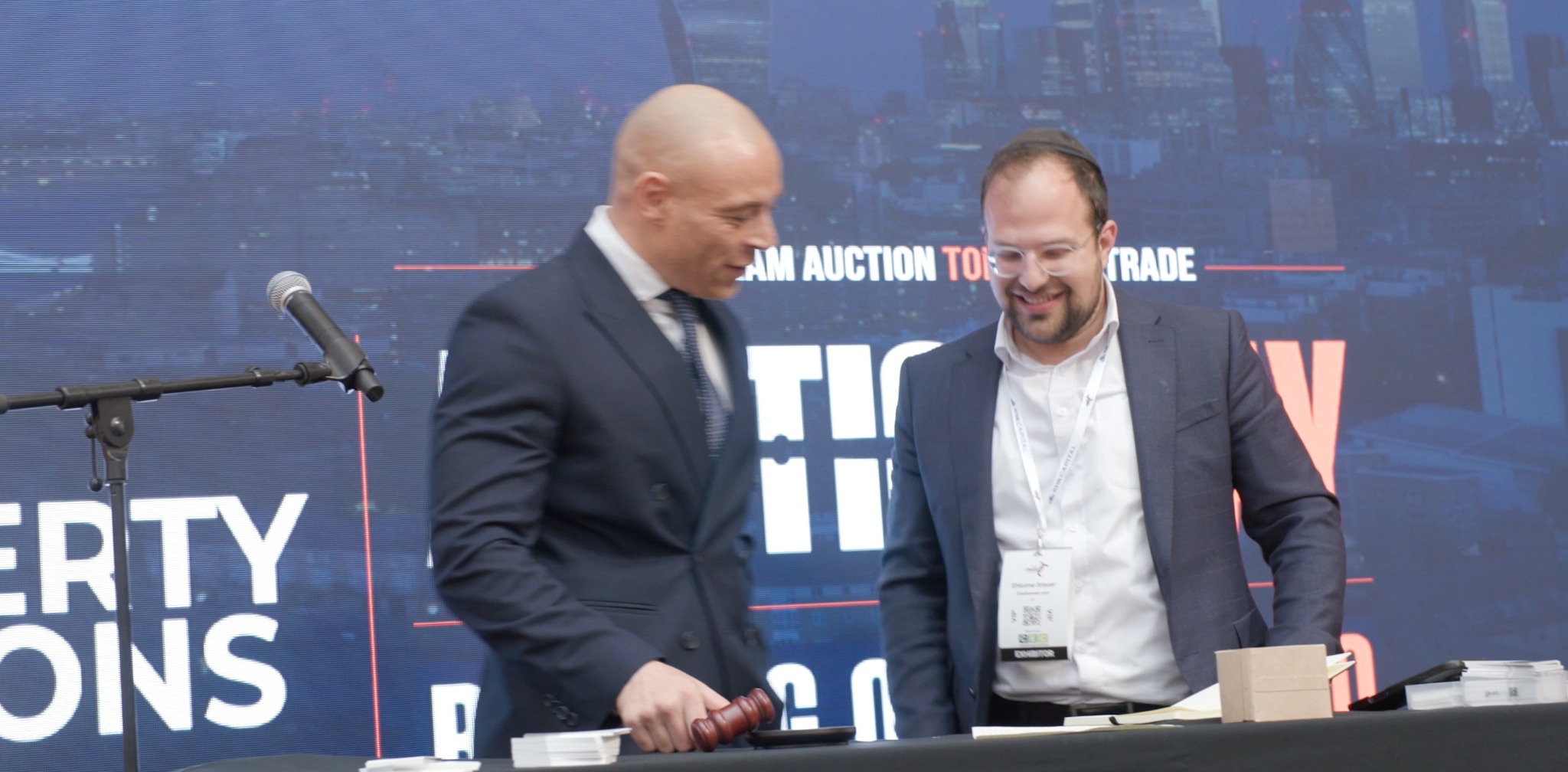 Two members of the Swift auction team together on stage